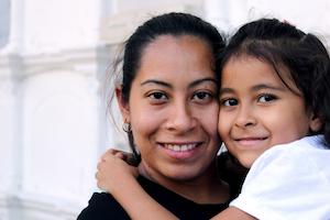 Woman standing and a girl near wall